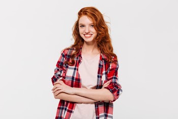Happy attractive young redhead lady with arms crossed. Free Photo