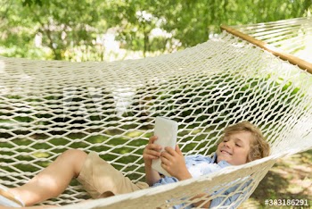 Happy boy using digital tablet in hammock