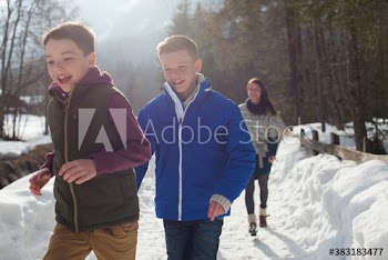 Happy brothers on sunny snowy footpath