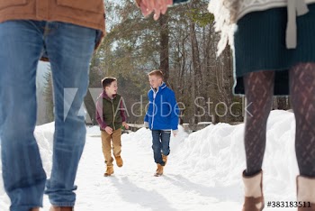 Happy brothers walking on snowy footpath