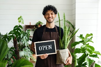 Happy business owner holding we are open sign | Free stock photo | High Resolution image