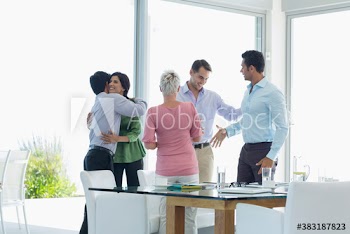 Happy business people hugging and shaking hands