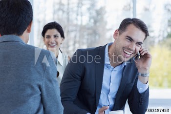 Happy businessman talking on smart phone and laughing
