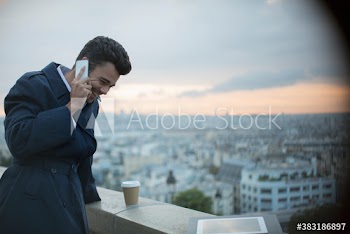 Happy businessman talking on smart phone, Montmartre, Paris, France