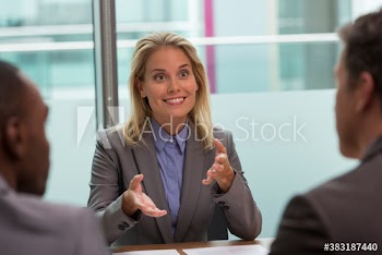 Happy businesswoman explaining in conference room meeting