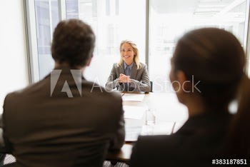 Happy businesswoman talking with colleagues in conference room meeting