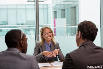 Happy businesswoman talking with colleagues in conference room meeting