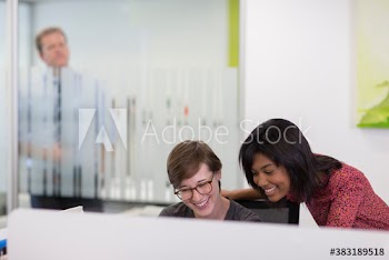 Happy businesswomen at computer in office