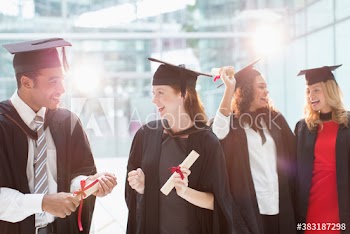Happy college students in caps and gowns graduating