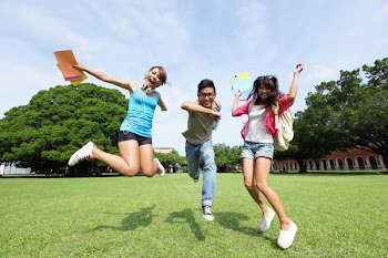 Happy College students jump and smile to you on campus lawn, asian