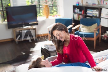 Happy couple cuddling on sunny sofa