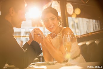Happy couple holding hands and drinking champagne in restaurant