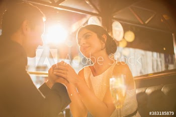Happy couple holding hands in sunny restaurant