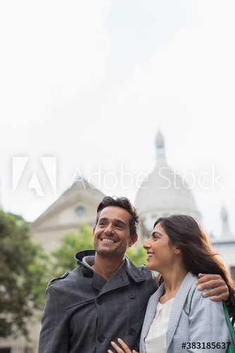 Happy couple hugging below Sacre Coeur, Paris, France