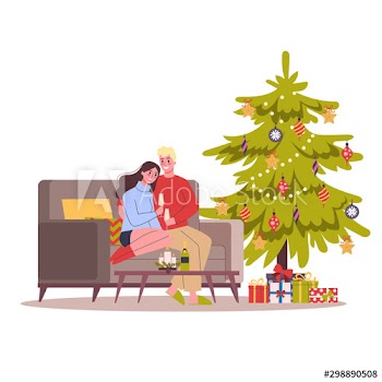 Happy couple sitting next to Christmas tree, holding glasses