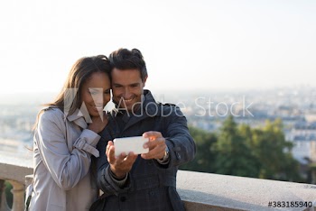 Happy couple taking selfie with camera phone, Paris, France