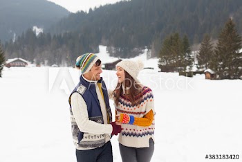Happy couple walking in snowy landscape