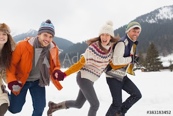 Happy couples friends running in snow