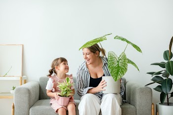 Happy daughter and mom holding potted plants | Free stock photo | High Resolution image