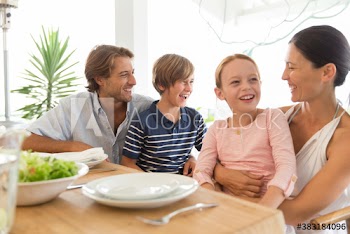 Happy family eating lunch at table