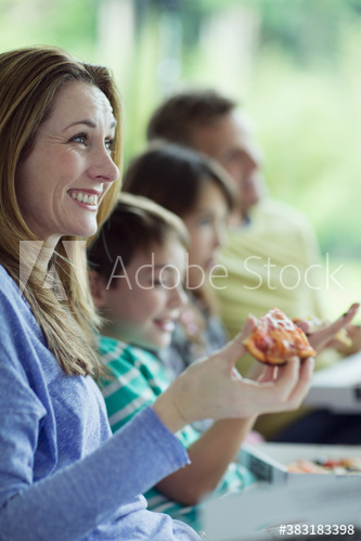 Happy family eating pizza and watching TV