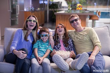 Happy family in 3D glasses watching movie on sofa