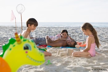 Happy family relaxing and building sandcastle on sunny beach