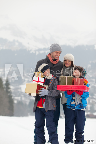 Happy family with Christmas gifts in snowy field