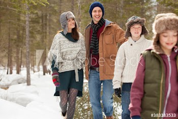 Happy family with Christmas tree in woods