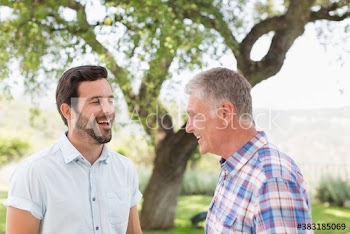 Happy father and adult son in park