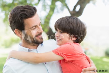 Happy father and son hugging in park