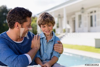 Happy father and son on sunny patio