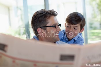 Happy father and son reading newspaper