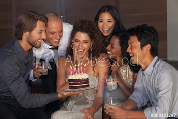 Happy friends celebrating birthday with cake at party