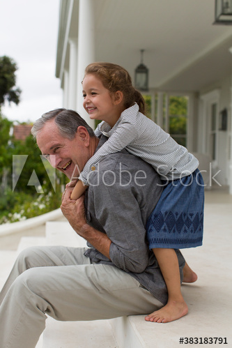 Happy grandfather and granddaughter on patio