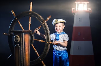 Happy little boy dressed in a sailor costume and captain's cap. The...