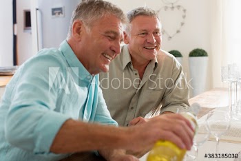 Happy male senior friends enjoying wine