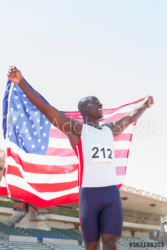 Happy male track and field athlete celebrating with American flag