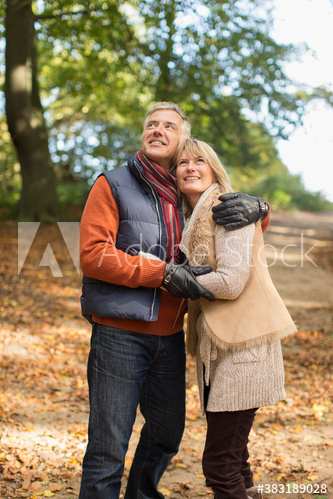 Happy mature couple hugging in autumn park