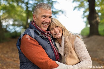 Happy mature couple hugging in autumn park
