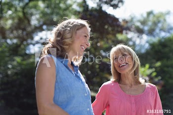Happy mother and adult daughter in sunny park
