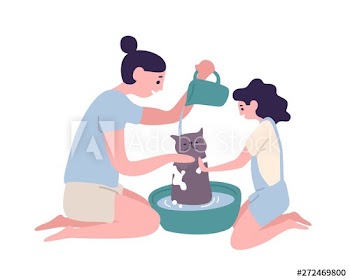 Happy mother and daughter washing cat at home