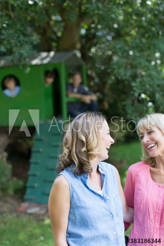 Happy mother and daughter with kids in backyard
