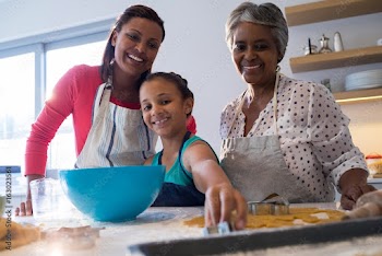 Happy multi-generation family preparing cookies in kitchen