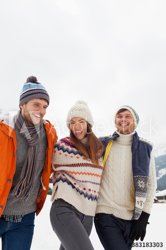 Happy playful friends walking in snow