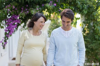 Happy pregnant couple in garden
