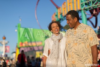 Happy senior couple at sunny amusement park