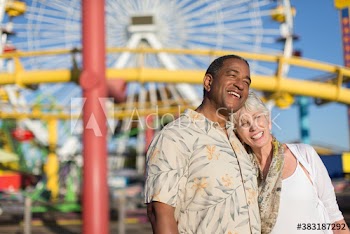 Happy senior couple at sunny amusement park