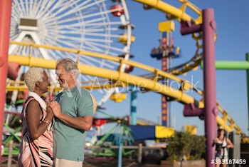 Happy senior couple at sunny amusement park