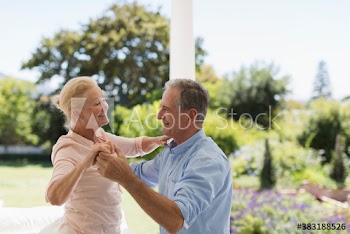 Happy senior couple dancing on patio